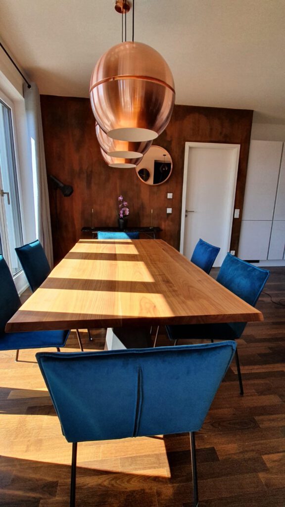Rostlampe und neue Stühle in Petrolblau im Hintergrund Rostwand und Industristil